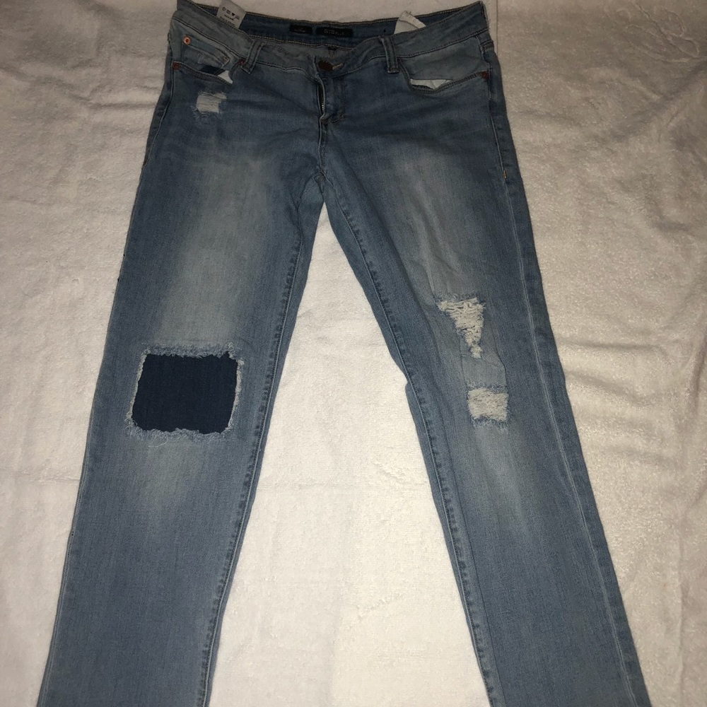 Blue jeans with blue patch and distressed knee.